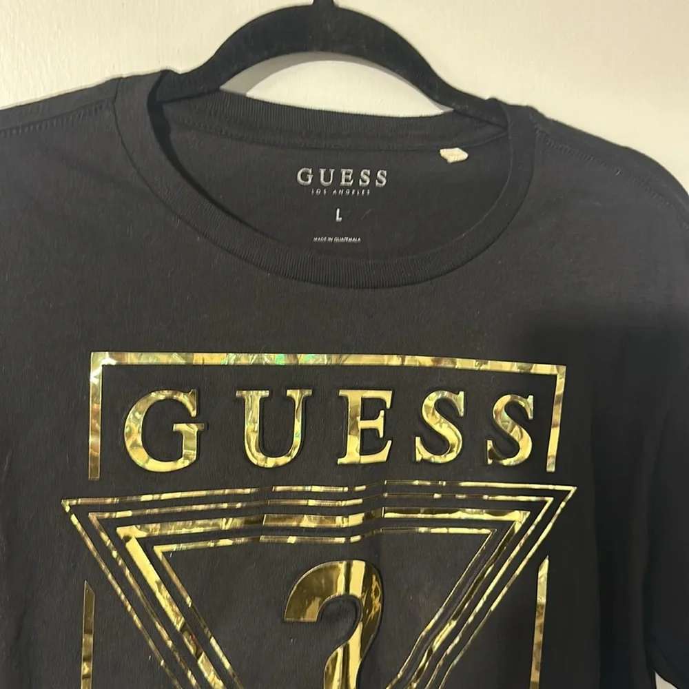 NWOT. Woman’s Guess black and gold T shirt in size L. - Picture 2 of 4